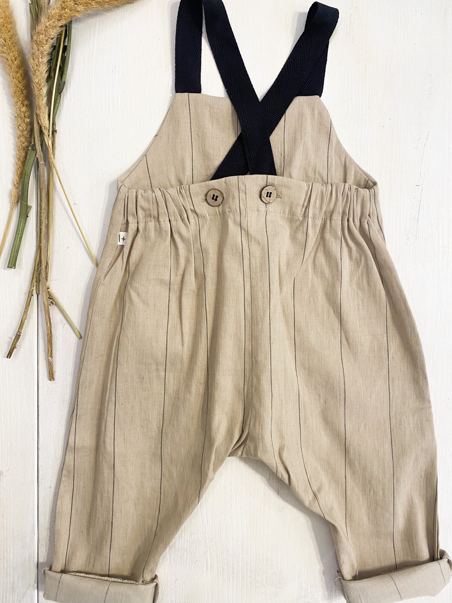 Salopette in cotone beige riga nera, bretelle nere.