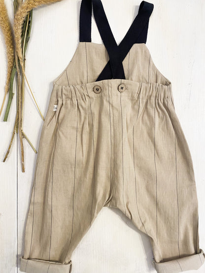 Salopette in cotone beige riga nera, bretelle nere.