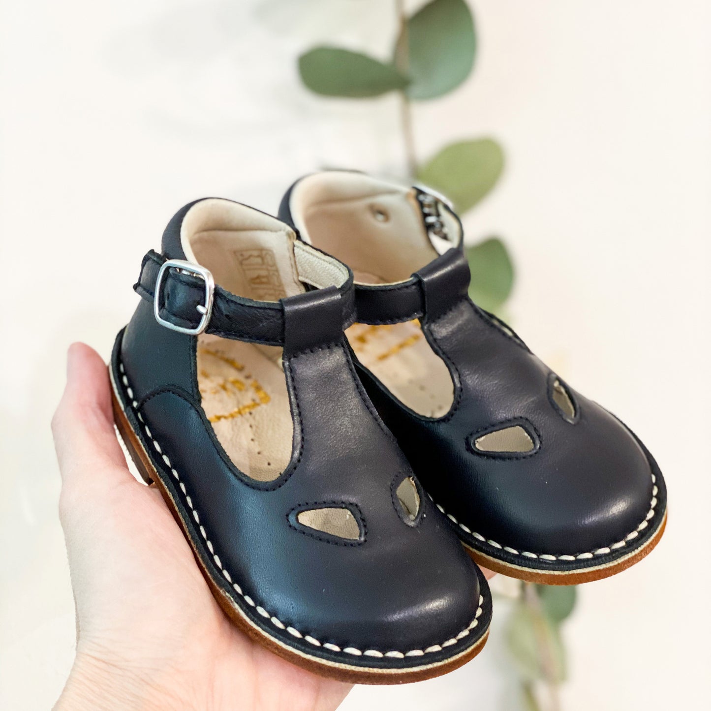Sandalino due occhi in pelle blu, con impunture. Chiusura con fibbia laterale, fondo in cuoio con antiscivolo, soletto in vera pelle con plantare anatomico. Adatte ai primi passi.