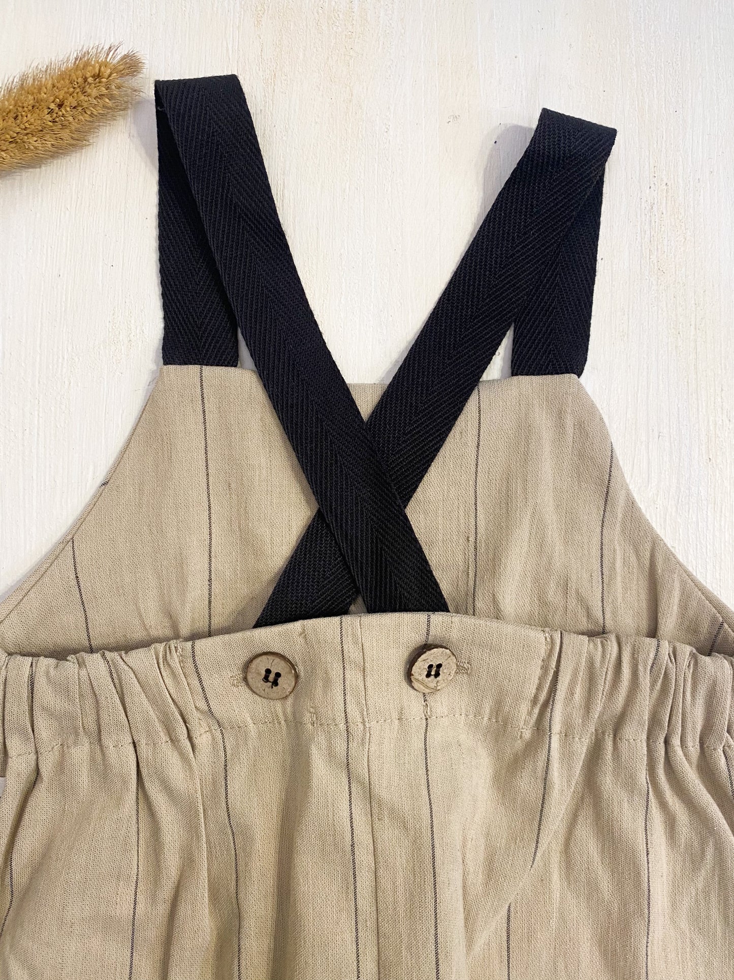 Salopette in cotone beige riga nera, bretelle nere.